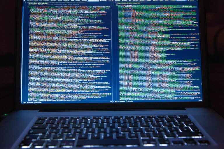 Laptop displaying source code with dual screens for software development.