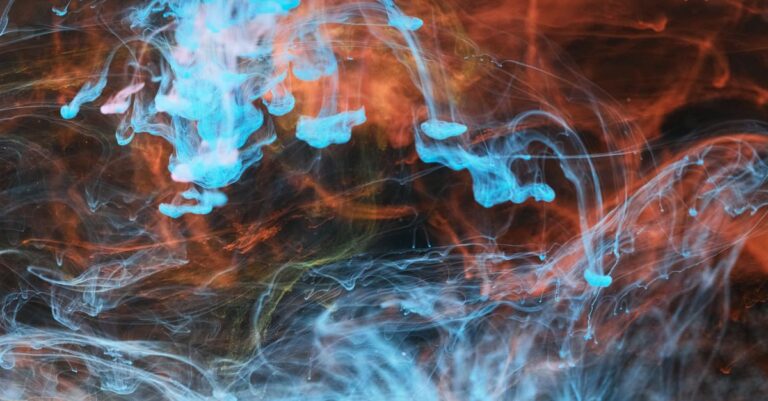 Vivid abstract artwork of swirling blue and orange ink diffusion creating intricate patterns.