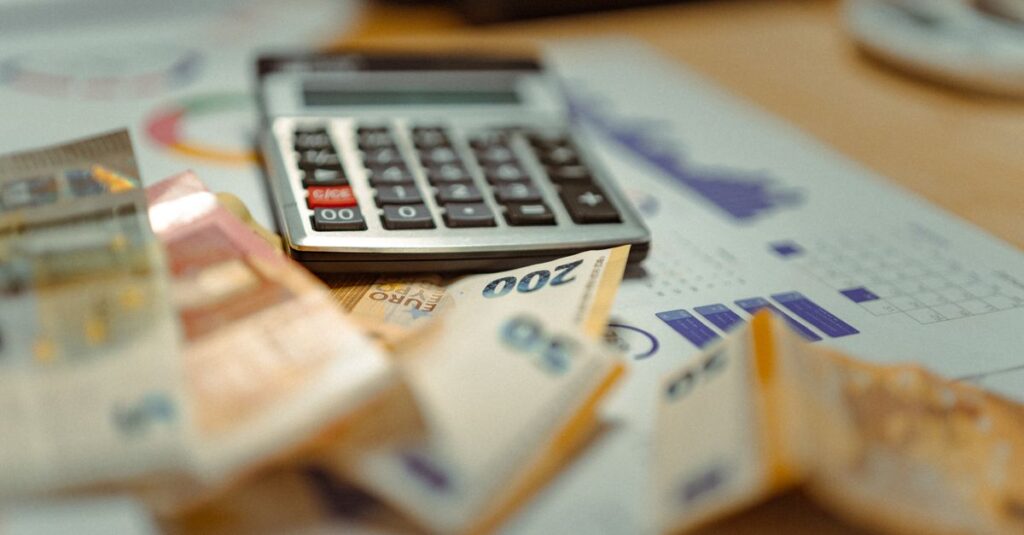 Euro banknotes and calculator on financial documents, focusing on business budget planning.