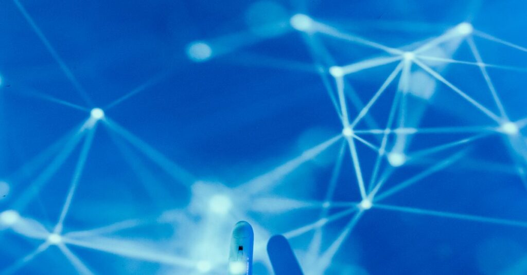 Futuristic robotic hand touching a digital network on a blue background.